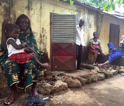 Kadiatou Abass, 40, sitzt mit ihrer Tochter vor ihrem Haus in einem Armenviertel der guineanischen Hauptstadt Conakry. In ihrer 