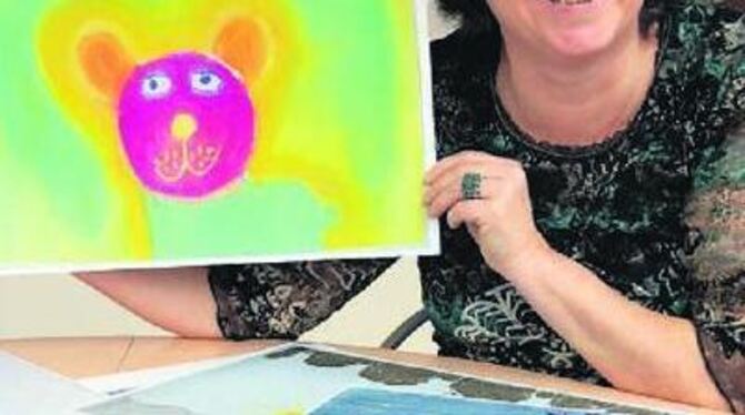 Bilder über Bilder: Die Kunsttherapeutin Kathrin Hillermann zeigt stolz die Arbeiten krebskranker Kinder und Jugendlicher.
FOTO