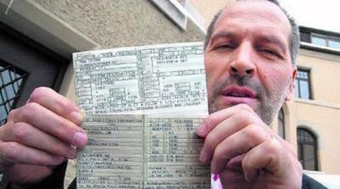 Thomas Leichtle mit einem älteren und einem Kraftfahrzeugschein jüngeren Datums. Darauf sind die &raquo;Emissions-Schlüsselnumme