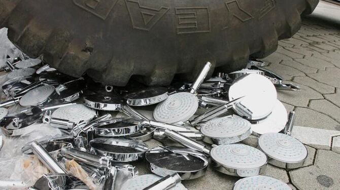 Mit einem Bagger werden beim Zoll in Stuttgart sichergestellte Plagiate von Duschköpfen zerstört. Foto: Bernd Weißbrod/Archiv