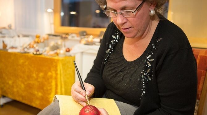 Mal mit dem Kirchenmotiv, mal mit der Jahreslosung. Mit Ausdauer, Augenmaß und ruhiger Hand bemalt Daniela Löbbe Christbaumkugel