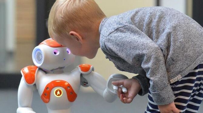 Ein kleines Kind zusammen mit Roboterkind »Nao«. Foto: CITEC/Universität Bielefeld