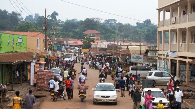 Eine Straßenszene aus Kampala: Händler bieten Waren an, Menschen kaufen ein. FOTO: DPA