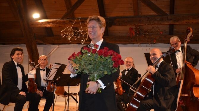 Rote Rosen an die Zuhörerinnen verteilte Bariton Ulrich Wand beim Konzert mit dem Johann Strauss Festival Orchester.  FOTO: SAND