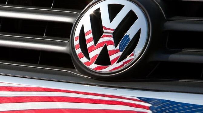 Eine US-Fahne spiegelt sich auf dem Logo und dem Kühlergrill eines VW-Wagens. Foto: Friso Gentsch