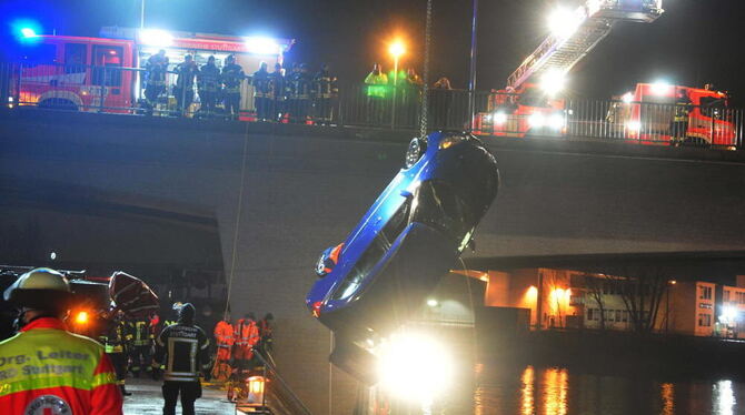 Rettungskräfte bergen ein Auto aus dem Neckar in Stuttgart. Das Fahrzeug war bei Eisglätte vom Uferdamm in den Fluss gerutscht.