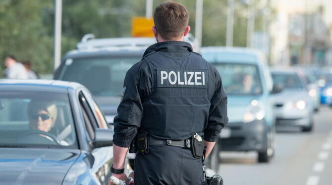Ein Bundespolizist kontrolliert an der deutsch-österreichischen Grenze in Simbach am Inn Fahrzeuge.