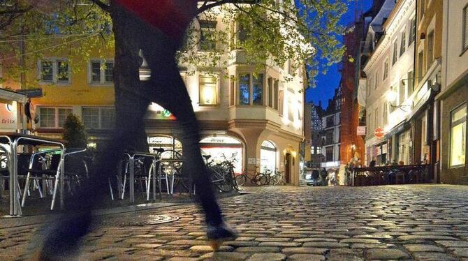 Eine Frau läuft nachts durch die Freiburger Innenstadt. Foto: Michael Bamberger/Illustration