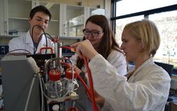 Die Schüler Lucas Mieth, Silvia Katolla und Verena Wolf am Bioreaktor (von links) mit einer Versuchsanordnung.  FOTO: SIEWE-REIN