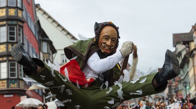 Ein Federahannes springt in Rottweil beim Narrensprung durch die Luft.