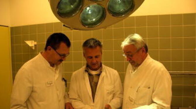 Chefarzt Dr. Frank Houben (Mitte) hält ein künstliches Hüftgelenk. Links Oberarzt Dr. Bernd Goller, rechts sein Kollege Oberarzt