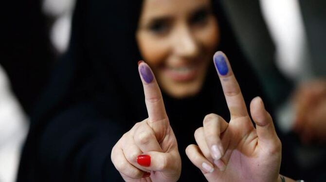 Iranerinnen zeigen nach der Stimmabgabe ihre mit Farbe markierten Finger. Foto: Abedin Taherkenareh