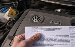 Ein Brief von Volkswagen zur Rückrufaktion zum Abgas-Skandal vor den Motor eines VW Passat Diesel. Foto: Armin Weigel
