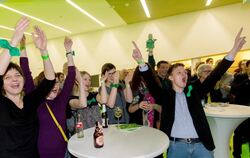 Parteianhänger der Grünen reagieren in Stuttgart auf die ersten Hochrechnungen.