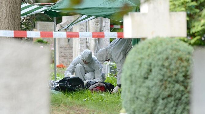 Mitarbeiter der Spurensicherung der Polizei untersuchen auf einem Friedhof in Stuttgart einen Tatort, an dem eine getötete Frau