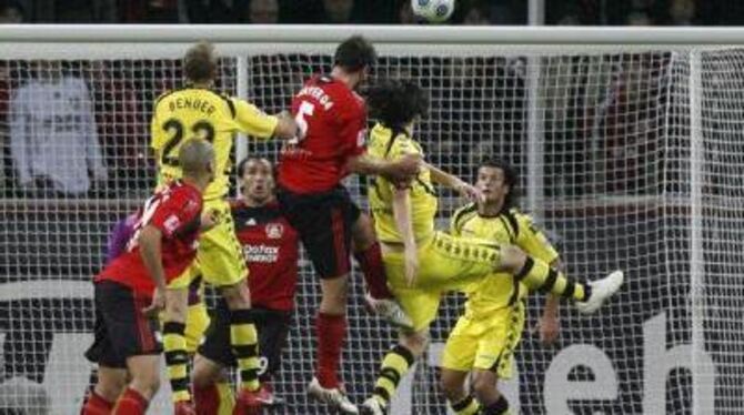 Der Leverkusener Manuel Friedrich (rotes Trikot) erzielt den Ausgleich zum 1:1 per Kopf.
FOTO: DPA