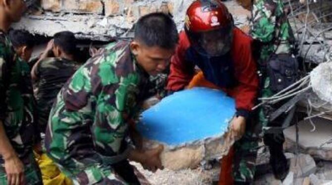 Helfer suchen in den Trümmern eines Hauses auf Sumatra nach Verschütteten.
FOTO: DPA