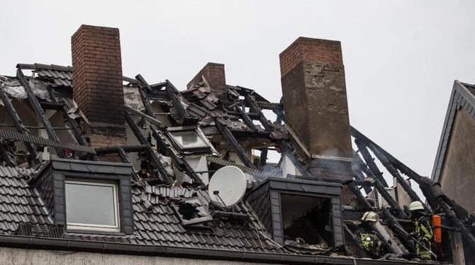 Feuerwehrleute arbeiten in einem ausgebrannten Wohnhaus. Foto: Maja Hitij