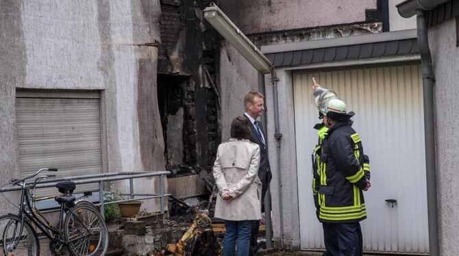 Der nordrhein-westfälische Innenminister Ralf Jäger lässt sich von Feuerwehrmännern den verlauf des verheerenden Brandes erkl
