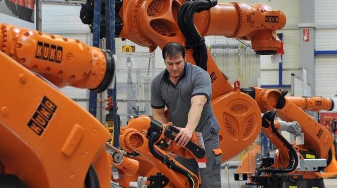 In Augsburg kontrolliert ein Arbeiter einen Roboter von Kuka: Der chinesische Konzern Midea will den deutschen Roboter- und A