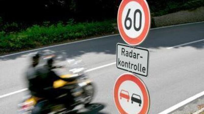 Wie im Fernsehen: Ein Motorradfahrer fährt an einem Schild mit der Aufschrift »Radarkontrolle« vorbei.
SYMBOLFOTO: DPA