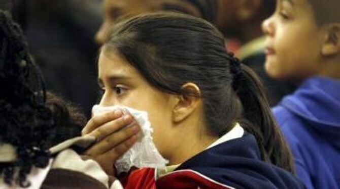 Ein Mädchen versucht sich in einer Bahnstation in New York vor einer Ansteckung mit der Schweinegrippe zu schützen.
FOTO: DPA