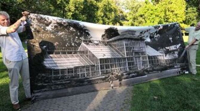 So hat das mal hier ausgesehen: Zwei Helfer zeigen die Leinwand mit einem Foto der Glas- und Eisen-Konstruktion. Das stark rampo