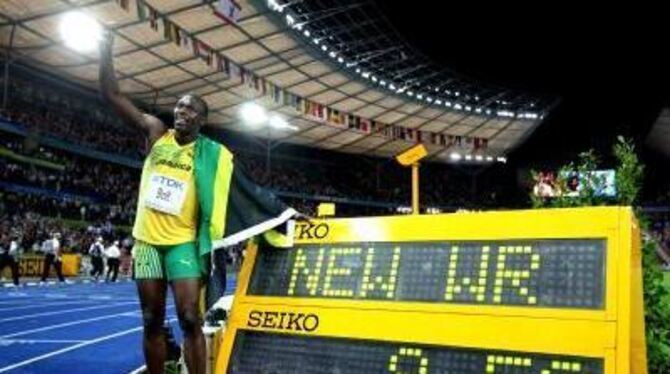 Usain Bolt posiert neben der Anzeigetafel, die seinen Weltrekord anzeigt. FOTO: DPA