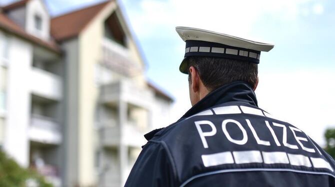 Der freiwillige Polizist Andreas K. steht in Ludwigshafen mit seiner Polizeiuniform vor einem Wohnhaus.