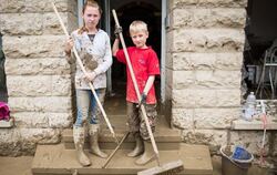 Die fleißigen Helfer Carolin (12) und Florian (8) stehen bei Aufräumarbeiten nach dem schweren Unwetter in Braunsbach vor dem Ge
