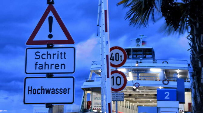 Schilder mit der Aufschrift »Schritt fahren -Hochwasser« weisen am Fährhafen von Meersburg auf das Hochwasser im Bodensee hin. F