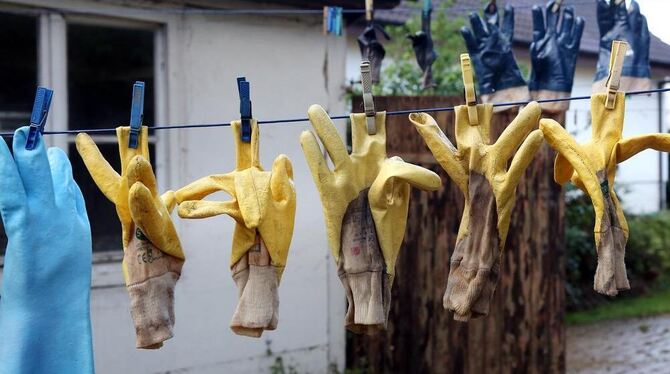 Nasse Arbeitshandschuhe hängen auf einer Wäscheleine bei Maselheim.