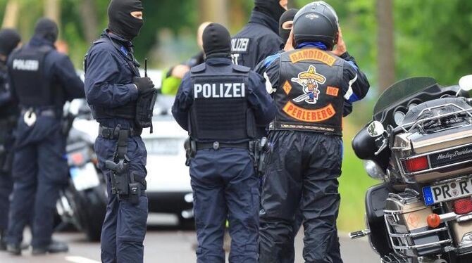 Polizeibeamte mit Sturmhauben überprüfen Teilnehmer eines Motorradfahrertreffens im Südwesten von Magdeburg. Foto: Jens Wolf