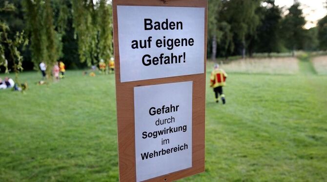 Ein Schild mit der Aufschrift: »Baden auf eigene Gefahr!« und »Gefahr durch Sogwirkung im Wehrbereich« an einem Weg in Munderkin