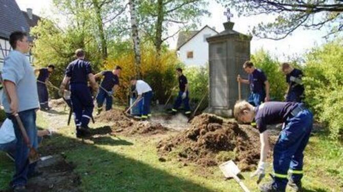 In Nehren putzen Jugendliche den Friedhof wieder sauber heraus.  FOTO: ULP