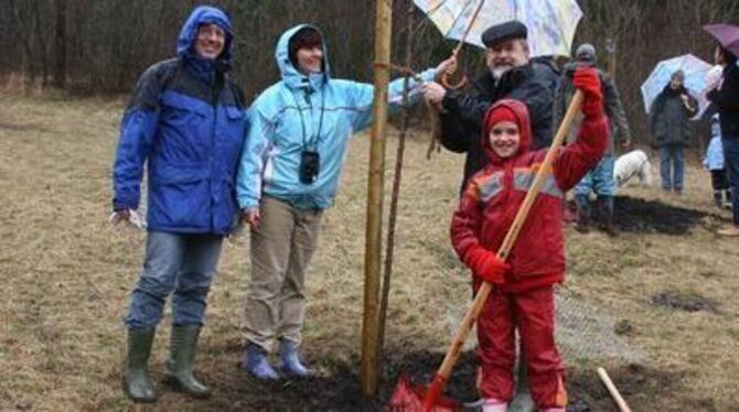 Die Familie Neubrander mit Tochter Lea und Bürgermeister Rudolf Heß (mit Regenschirm) bei der Pflanzaktion.
FOTO: SRE