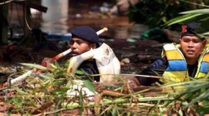 Nach dem Dammbruch in Jakarta suchen Helfer  Überlebende. FOTO: DPA