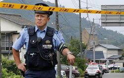 Ein Polizist sichert die Straße zum Tatort. foto: Kimimasa Mayama