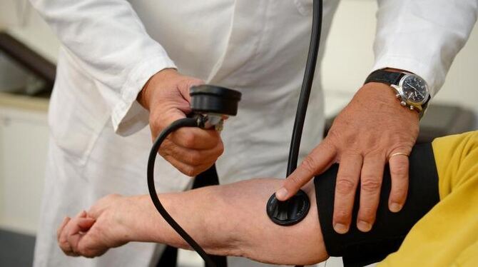 Ein Hausarzt misst einer Patientin den Blutdruck. Foto: Bernd Weißbrod