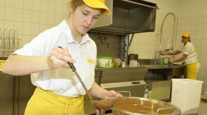 Traditionelle Handwerkskunst der Bäcker und Konditoren: So wird die Torte in Schokolade gehüllt. 
FOTO: NIETHAMMER
