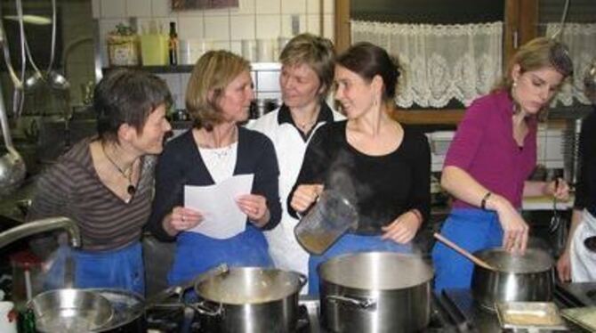 Bei munteren Gesprächen und Hildegard-Zutaten wird der Kochkurs mit Inge Tress (Mitte) zum Happening am Herd.
GEA-FOTO: GEIGER