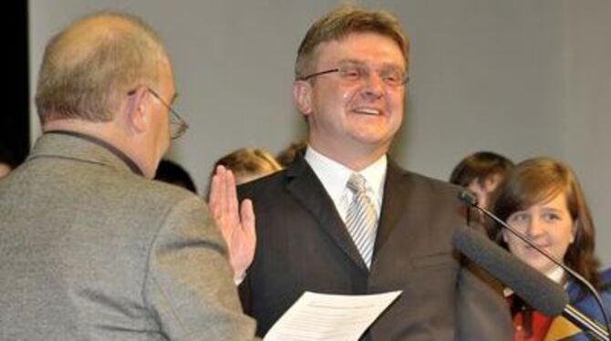 Gerhard Steinhart (links) nimmt Bad Urachs neuem Bürgermeister Elmar Rebmann den Eid ab.   
FOTO: NIETHAMMER
