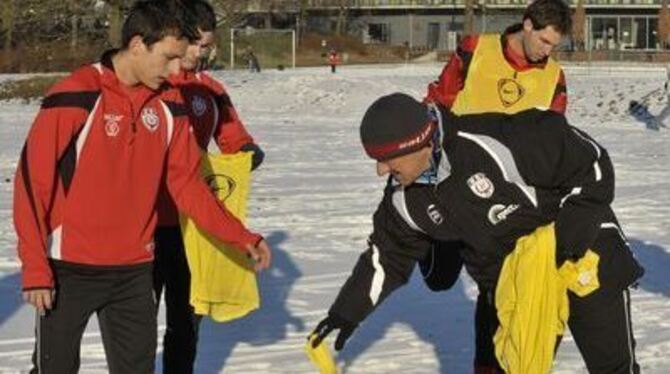 Trainingsauftakt in der Winterlandschaft: SSV-Trainer Roland Seitz (rechts vorne) verteilt die Leibchen. 
FOTO: NIETHAMMER